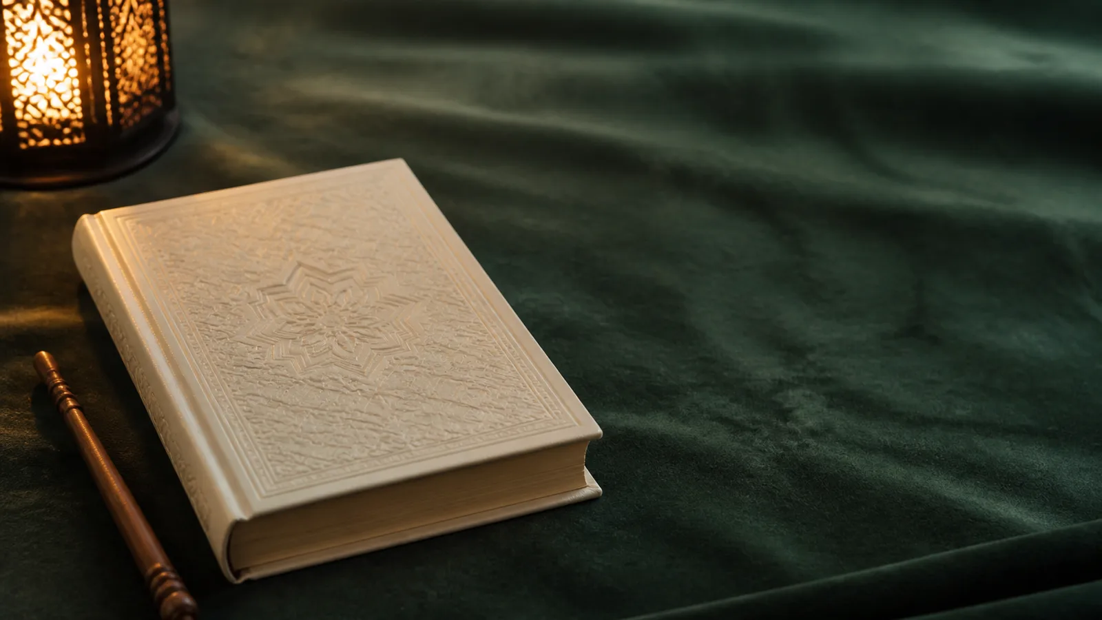 A closed embossed mushaf on dark green cloth with a wooden reading pointer and a lantern