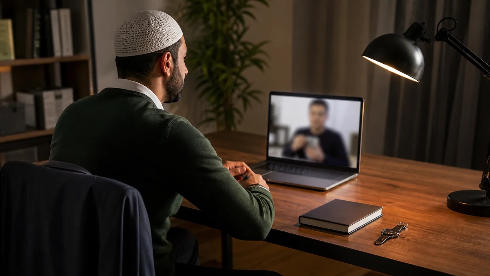 A working adult taking a private online Quran class at a quiet evening desk